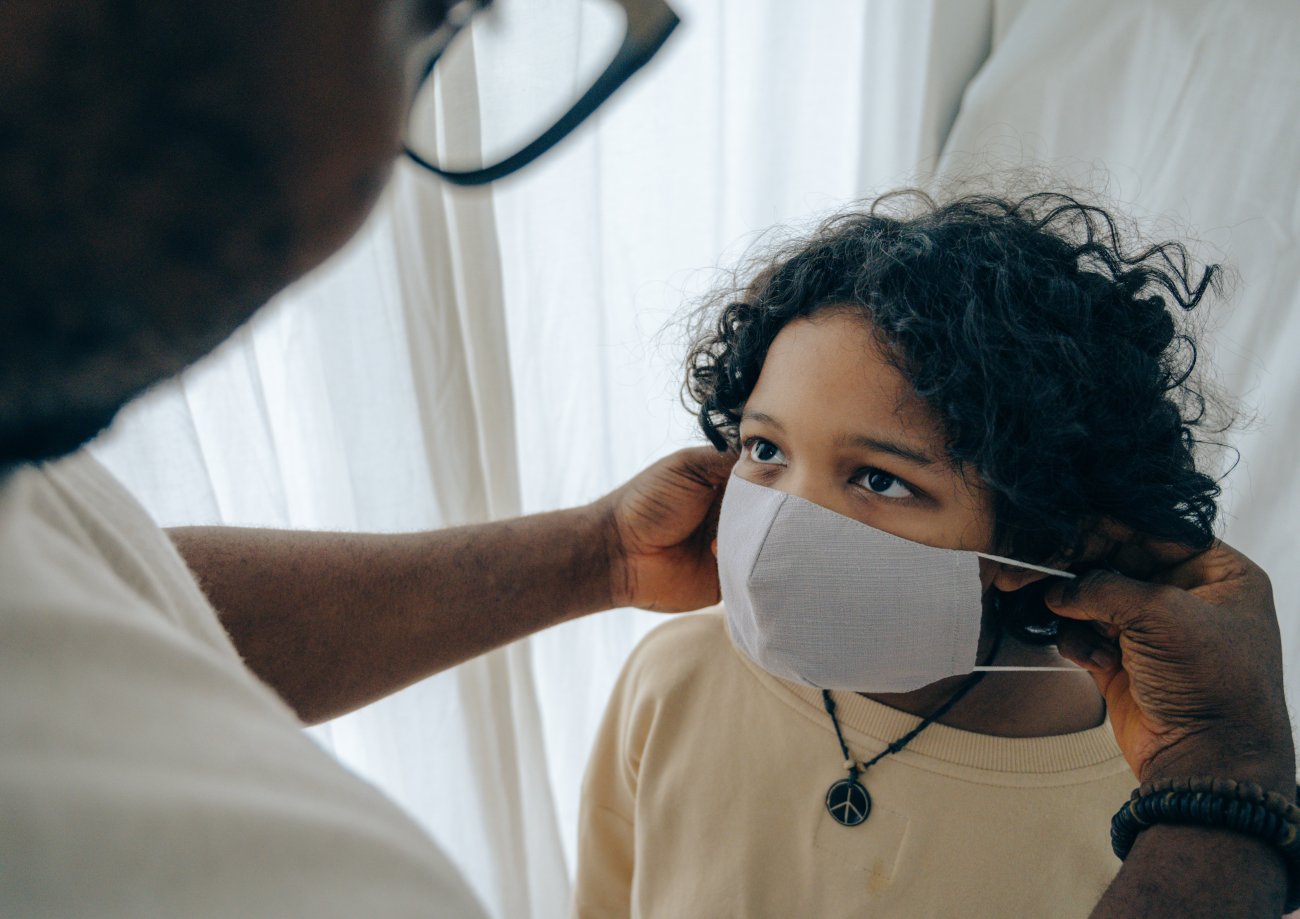 Child having a mask fitted by an adult.